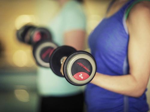 a woman is holding a pair of dumbbells at Mercure Melbourne Albert Park in Melbourne