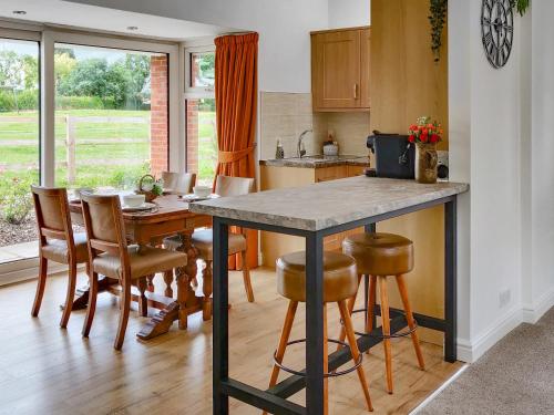 a kitchen with a table and some chairs and a table at The Crofts in Winsford