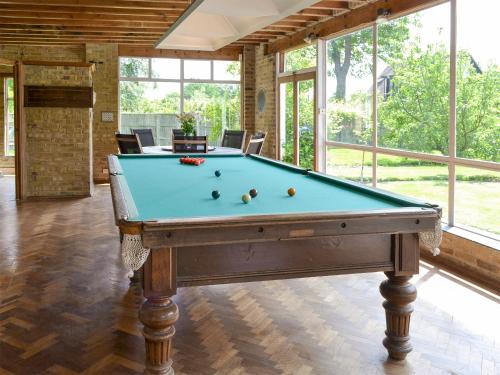a pool table in a room with windows at The Sanctuary in Little Chart