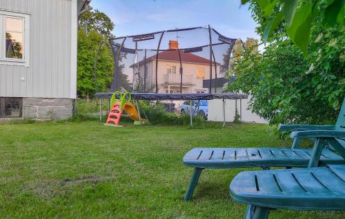 a playground with a slide and two benches in a yard at Gorgeous Home In Tingsryd With Kitchen in Tingsryd