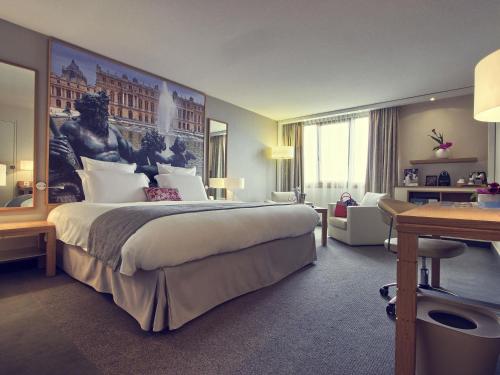 a bedroom with a large bed with a large painting on the wall at Mercure Paris Velizy in Vélizy-Villacoublay