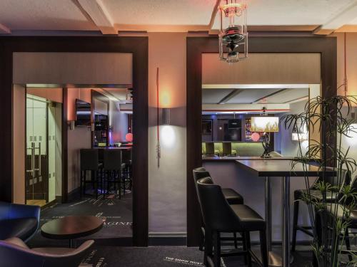 a bar in a restaurant with chairs and a table at Mercure Paris Velizy in Vélizy-Villacoublay