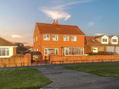 ein Haus mit einem davor geparkten Auto in der Unterkunft Merrywind in Beadnell