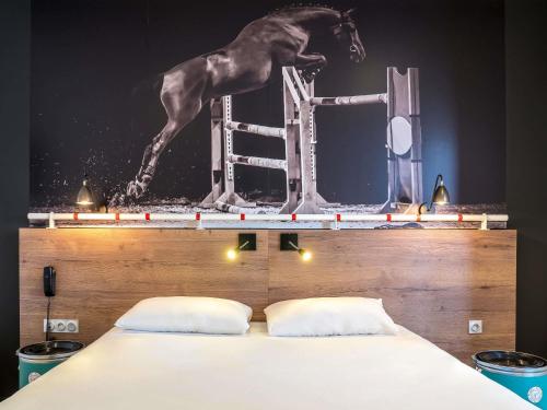 a horse jumping on the back of a bed at ibis Styles Saumur Gare Centre in Saumur