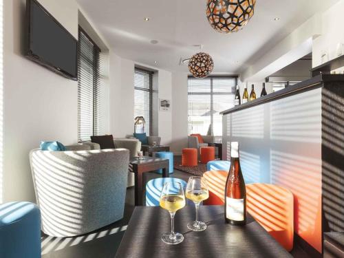a restaurant with two glasses of wine on a table at ibis Styles Saumur Gare Centre in Saumur