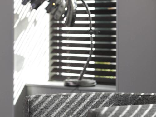 a table with a lamp in front of a window at ibis Styles Saumur Gare Centre in Saumur