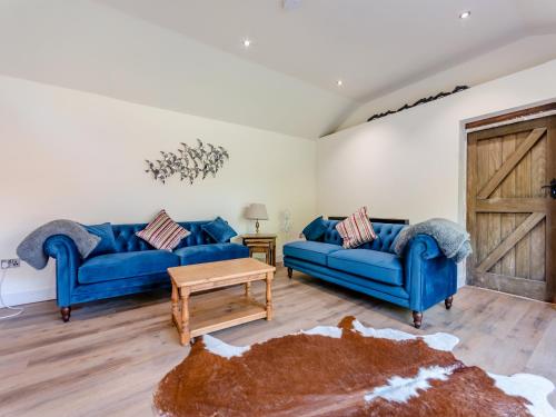a living room with two blue couches and a table at Red Brick Barn - Uk39916 in Howell