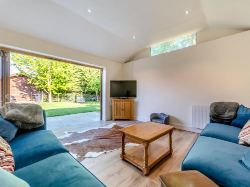 a living room with two blue couches and a tv at Red Brick Barn - Uk39916 in Howell