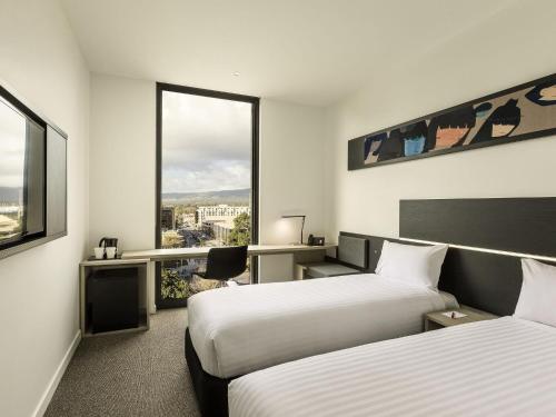 a hotel room with two beds and a window at ibis Adelaide in Adelaide