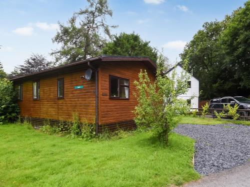 a small wooden cabin in a grassy yard at The Beehive C29 - Uk45926 in Newtown