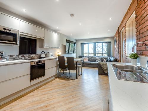 an open kitchen and living room with a couch at The Barn Owl - Uk36217 in Bowness-on-Solway