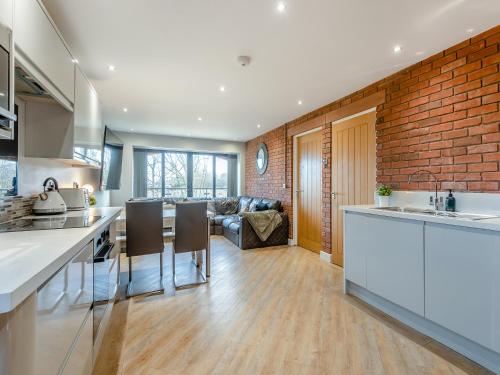 a kitchen and living room with a brick wall at The Barn Owl - Uk36217 in Bowness-on-Solway