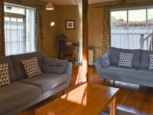 a living room with two couches and a table at Letterbox Cottage in Far Sawrey