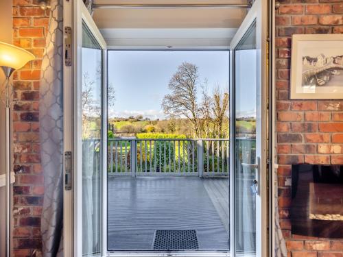 a sliding glass door leading to a balcony with a view at Ty Teiliwr - Uk45719 in Brynteg