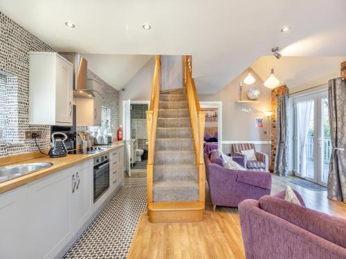a kitchen and living room with a staircase in a house at Ty Teiliwr - Uk45719 in Brynteg