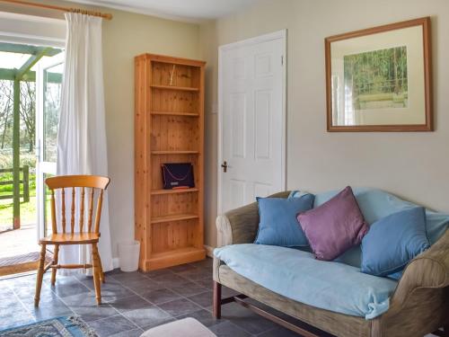 a living room with a blue couch and a chair at Beachside in Llanstephan