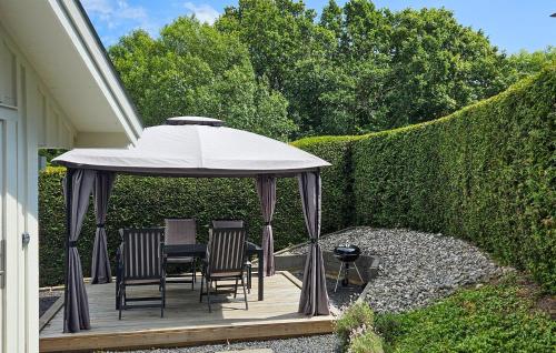 a gazebo with chairs and an umbrella on a patio at Amazing Home In Nättraby With Kitchen in Nättrabyhamn