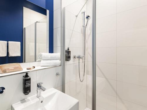 a bathroom with a shower and a sink at ibis budget Ludwigsburg in Ludwigsburg