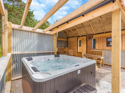 ein Whirlpool auf der Terrasse eines Hauses in der Unterkunft The Larches - Uk46804 in Culbokie