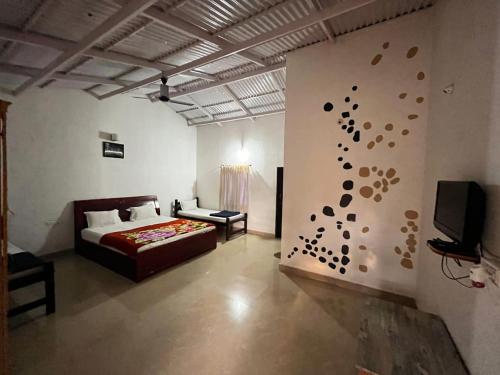 a bedroom with a bed and a tv on a wall at The Big Cat's Den - Maravakandy Resort, Masinagudi in Masinagudi