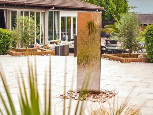 a garden with a pillar in the middle of a yard at Mercure Milton Keynes Hotel in Milton Keynes