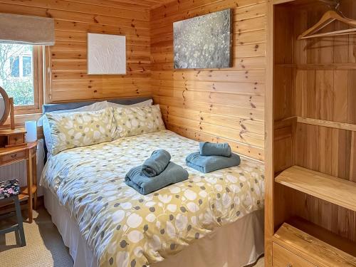 a bedroom with a bed with two towels on it at Wild Grape Lodge in Fritton Norfolk