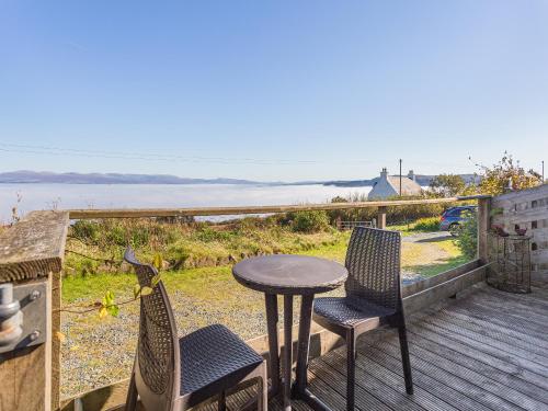 un tavolo e delle sedie su un ponte con vista sull'oceano di Single Malt Cottage a Geary