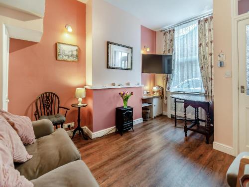 a living room with a couch and a desk at Sea Dog Cottage in Scarborough