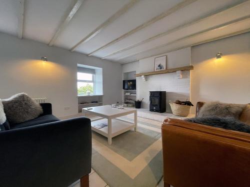 a living room with a couch and a table at Lower Hilton Cottage in Culrain