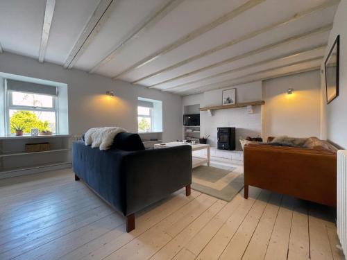 a living room with a blue couch and a fireplace at Lower Hilton Cottage in Culrain
