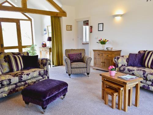 a living room with couches and a coffee table at Swallows Nest in Soulby
