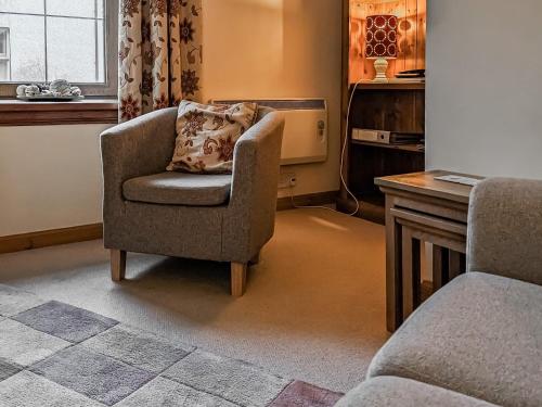 a chair with a pillow in a living room at Little Tigh Craggan - Uk10204 in Weem