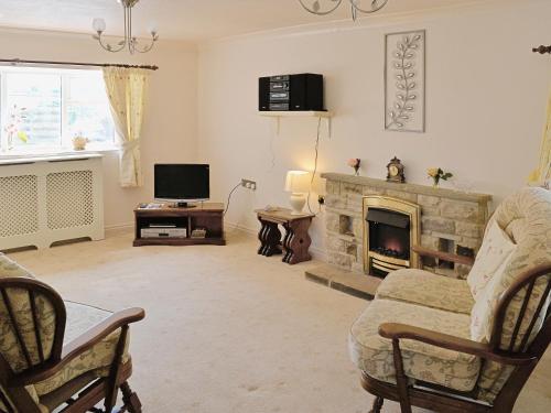 a living room with a fireplace and a tv at Fellbeck -9565 in Grantley