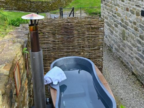 a bath tub sitting next to a brick wall at Tiggywinkle Cottage in Hawnby