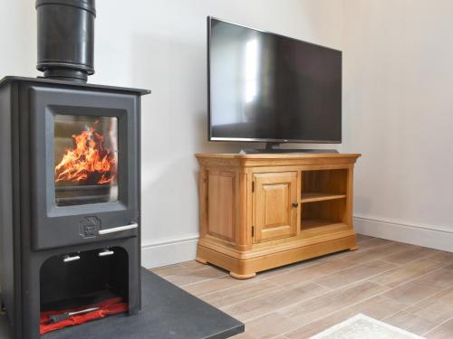 a living room with a fireplace and a flat screen tv at Apple Tree Barn- Uk40791 in Church Minshull