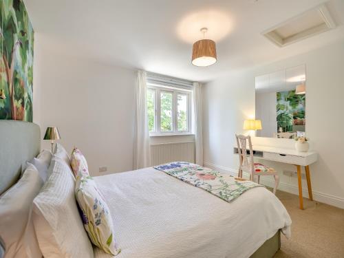 a bedroom with a bed and a desk and a window at The Nest in Surfleet