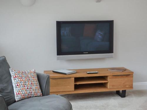 een woonkamer met een tv en een salontafel bij St Monicas in Fowey