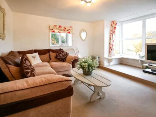 a living room with a couch and a table at Chainbridge Cottage in Whitby