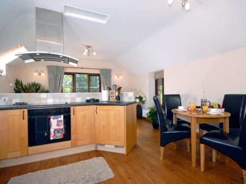 Una cocina y un comedor con mesa y sillas. en The Hayloft, en Walton West