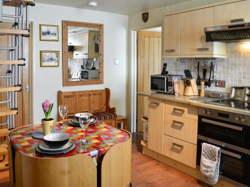 a kitchen with a table with wine glasses on it at Whitton View Nr Wooler in Milfield