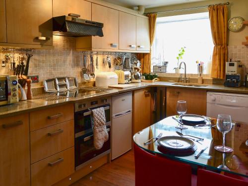 a kitchen with a table with wine glasses on it at Whitton View Nr Wooler in Milfield