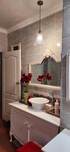 a kitchen with a white sink and a mirror at Leopard Lily in Potchefstroom