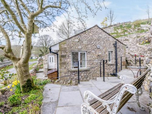 a stone house with a bench in front of it at Limecroft in Malham