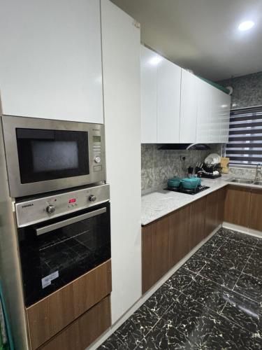 una cocina con estufa y microondas en CnP luxury 1 bedroom apartment Lekki, en Ikuata