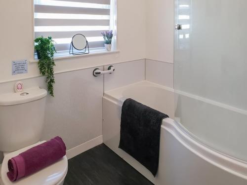 a bathroom with a tub and a toilet and a sink at The Hobbit in Inverallochy