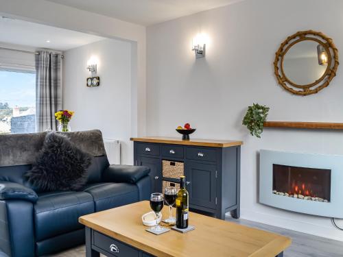 a living room with a couch and a table with wine glasses at Anchor Cottage in Portpatrick