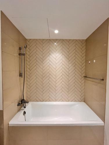 a bath tub in a bathroom with a wall at The Opal residence IBR in Sharjah