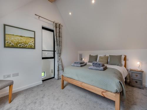 a bedroom with a bed with blue pillows on it at Dunley Barn in Winterslow