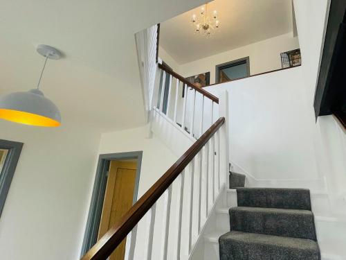 a staircase in a house with white walls and a hallway at Warren Lodge in Little Baddow