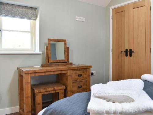 a bedroom with a table with a mirror and a bed at White Heather Barn in Swanwick